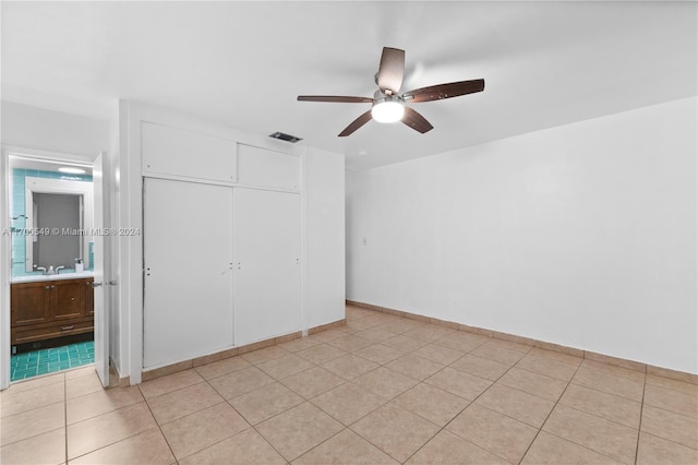 unfurnished bedroom featuring ceiling fan, a closet, and light tile patterned floors