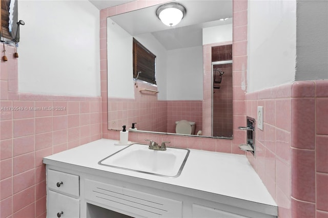 bathroom with vanity, tile walls, and toilet