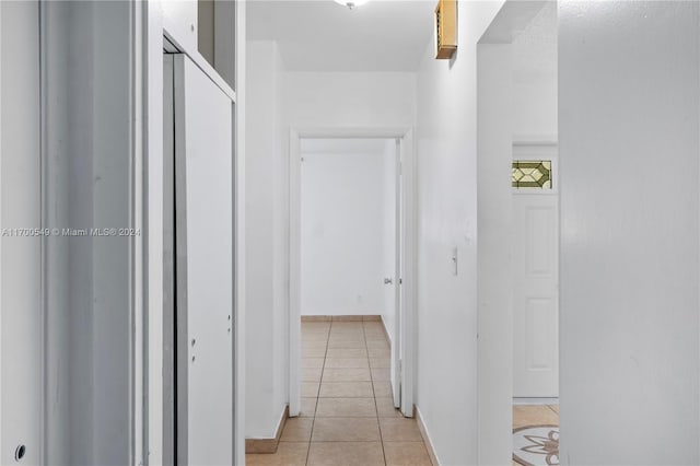 hall featuring light tile patterned floors