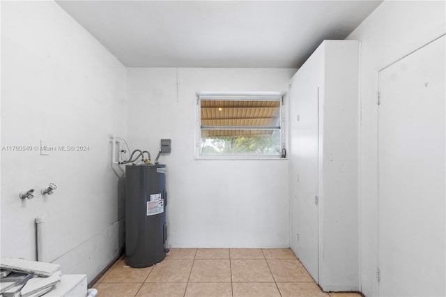 interior space featuring electric water heater and light tile patterned floors