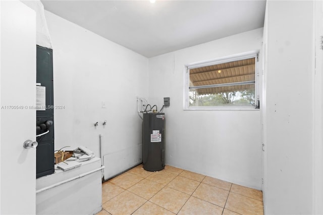 laundry room with light tile patterned floors and electric water heater