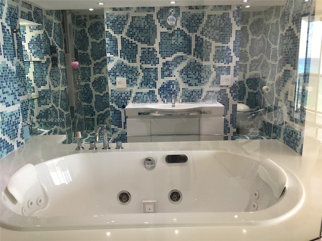 bathroom featuring vanity, a bathtub, and tile walls