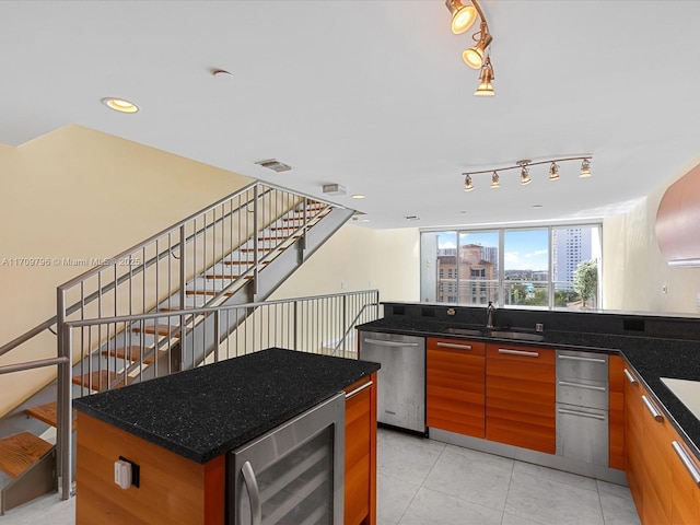 kitchen featuring a kitchen island, sink, wine cooler, dark stone counters, and stainless steel dishwasher