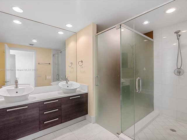 bathroom with tile patterned floors, a shower with shower door, and vanity