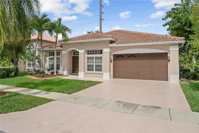 mediterranean / spanish home with a garage and a front lawn