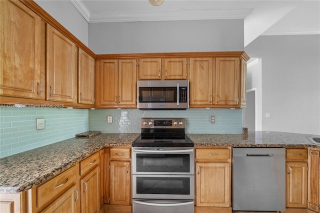 kitchen with decorative backsplash, dark stone countertops, crown molding, and stainless steel appliances