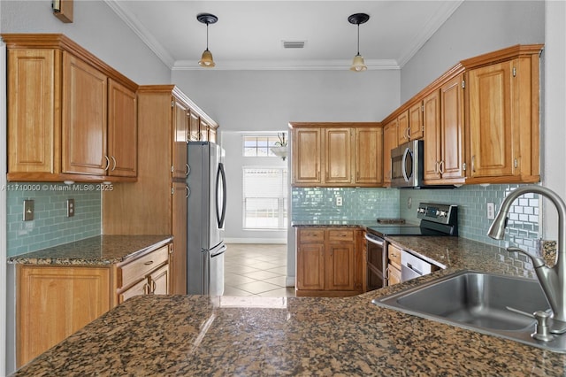 kitchen featuring appliances with stainless steel finishes, sink, crown molding, and pendant lighting