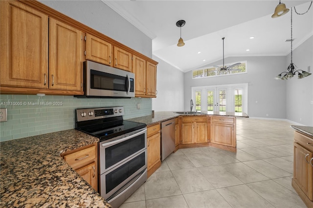 kitchen featuring kitchen peninsula, backsplash, appliances with stainless steel finishes, and pendant lighting