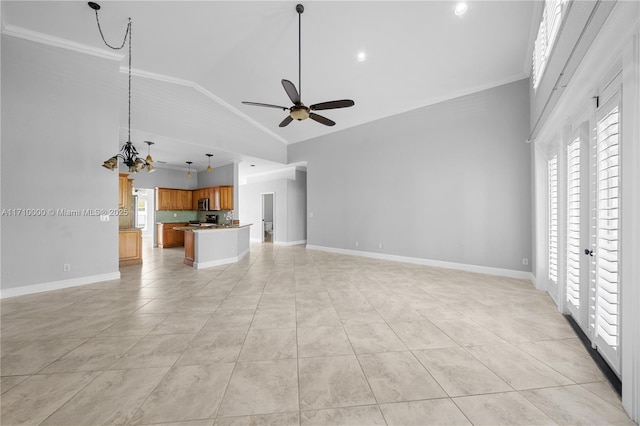 unfurnished living room with ceiling fan with notable chandelier, light tile patterned floors, and ornamental molding