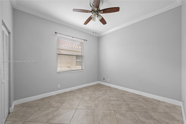 tiled empty room with ceiling fan and ornamental molding