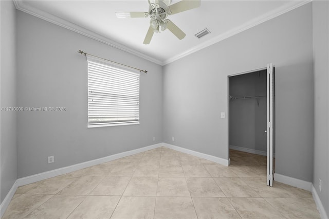 unfurnished bedroom featuring ceiling fan, a spacious closet, ornamental molding, light tile patterned floors, and a closet