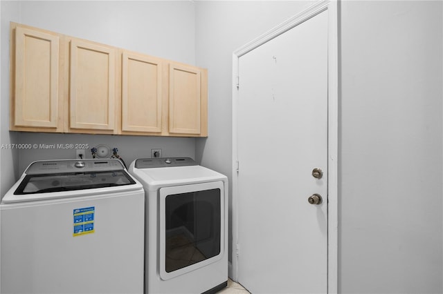 laundry area featuring washer and dryer and cabinets