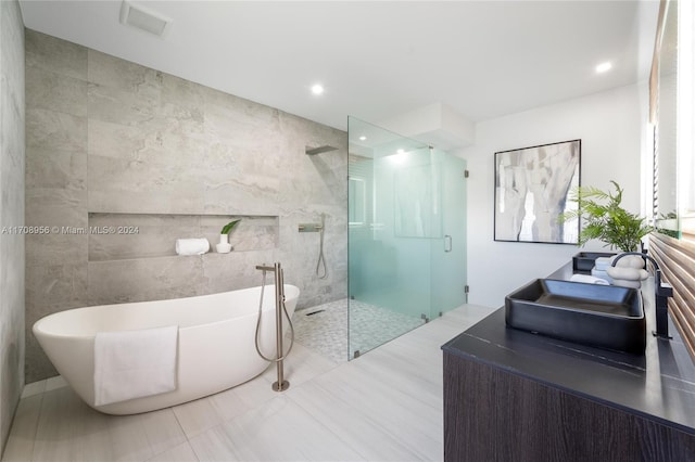 bathroom featuring sink, tile walls, and shower with separate bathtub