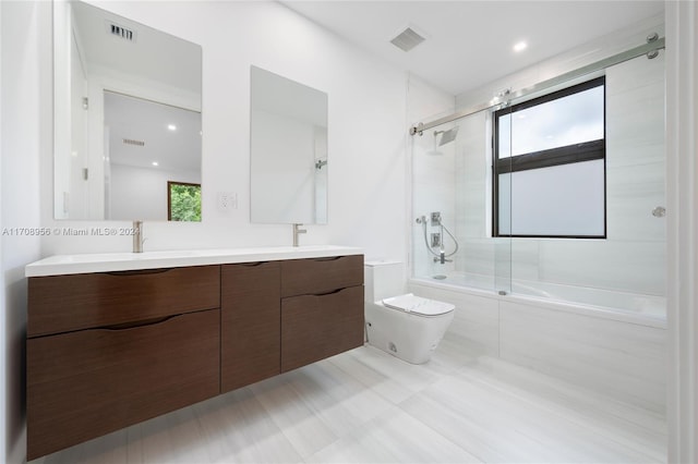 full bathroom featuring shower / bath combination with glass door, vanity, and toilet