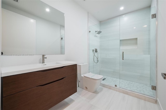 bathroom with vanity, toilet, and a shower with shower door