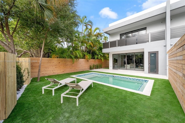 view of pool with a lawn and a patio