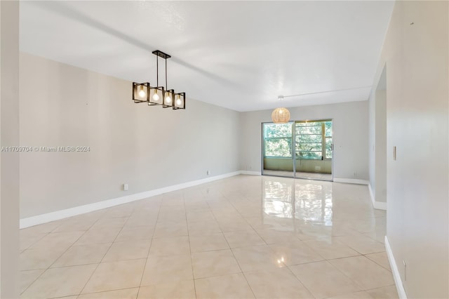 tiled empty room with a chandelier