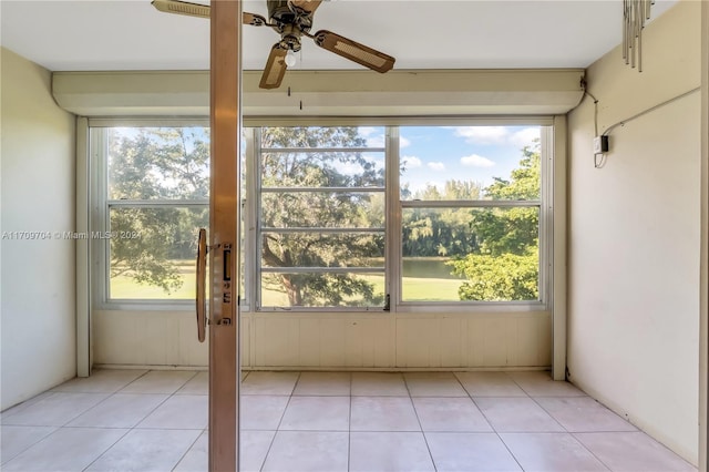 unfurnished sunroom with a water view and ceiling fan