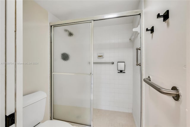 bathroom featuring toilet and an enclosed shower