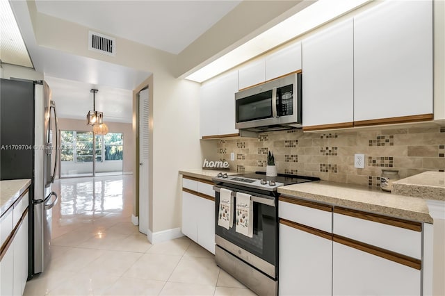 900 SW 125th Way Unit 304R, Pembroke Pines, FL 33027 - kitchen with appliances with stainless steel finishes, decorative backsplash, white cabinets, and light tile patterned floors