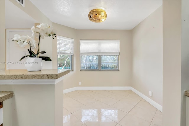 unfurnished dining area featuring light tile patterned floors