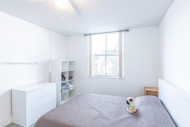 bedroom featuring ceiling fan and a textured ceiling