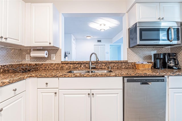 kitchen with white cabinets, decorative backsplash, sink, and stainless steel appliances