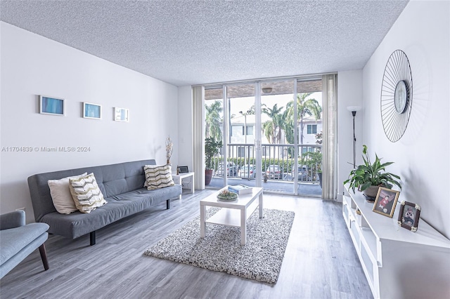 living room featuring a textured ceiling, hardwood / wood-style flooring, and a wall of windows