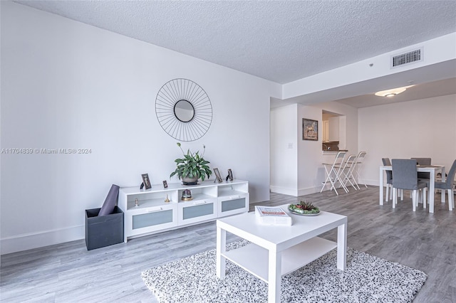 living room with hardwood / wood-style flooring and a textured ceiling