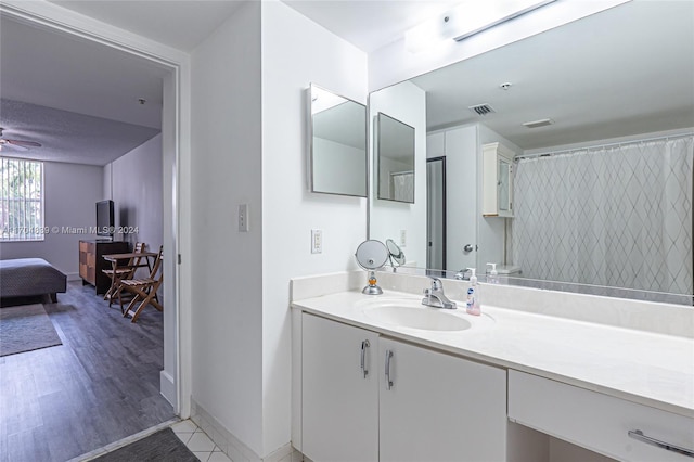 bathroom with vanity, hardwood / wood-style flooring, ceiling fan, and curtained shower