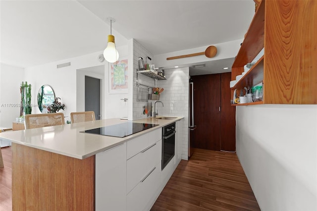 kitchen featuring dark hardwood / wood-style flooring, sink, black appliances, white cabinets, and hanging light fixtures