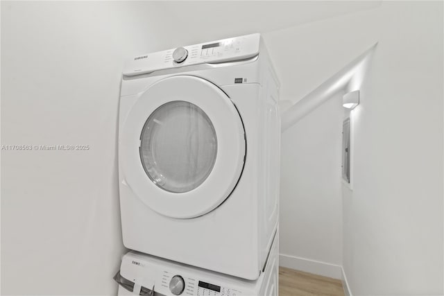 laundry area featuring light hardwood / wood-style floors and stacked washer and dryer