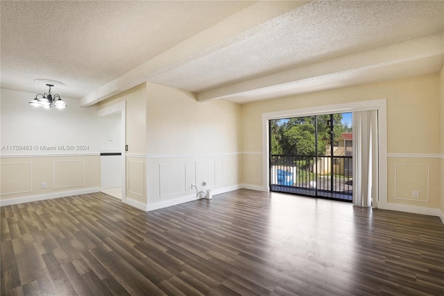 spare room with a chandelier, beam ceiling, a textured ceiling, and dark wood-type flooring