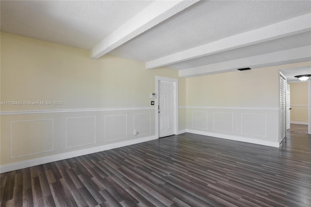 empty room featuring beamed ceiling and dark hardwood / wood-style flooring