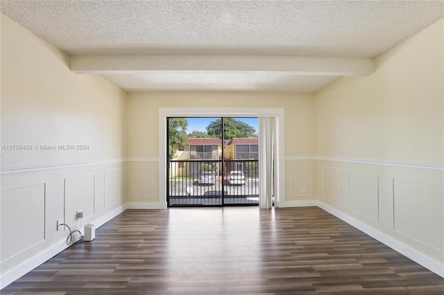 empty room with beam ceiling, dark wood-type flooring, and a textured ceiling