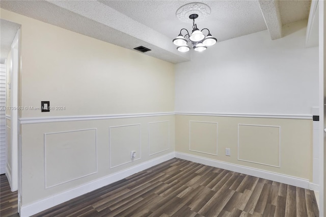 unfurnished room with dark hardwood / wood-style flooring, beamed ceiling, a textured ceiling, and an inviting chandelier