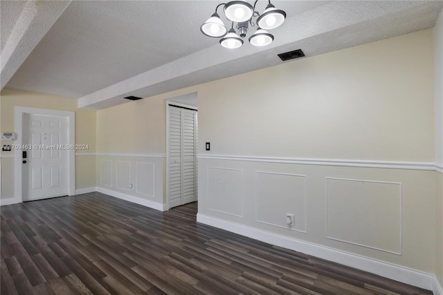 unfurnished room featuring dark hardwood / wood-style floors and a textured ceiling