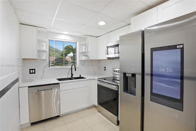 kitchen with a drop ceiling, white cabinetry, sink, and appliances with stainless steel finishes