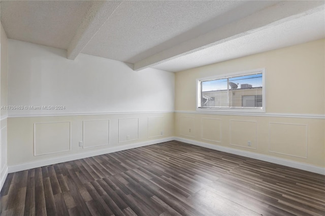 empty room featuring beamed ceiling, dark wood-type flooring, and a textured ceiling