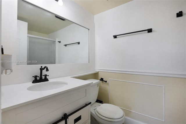 bathroom featuring an enclosed shower, vanity, and toilet