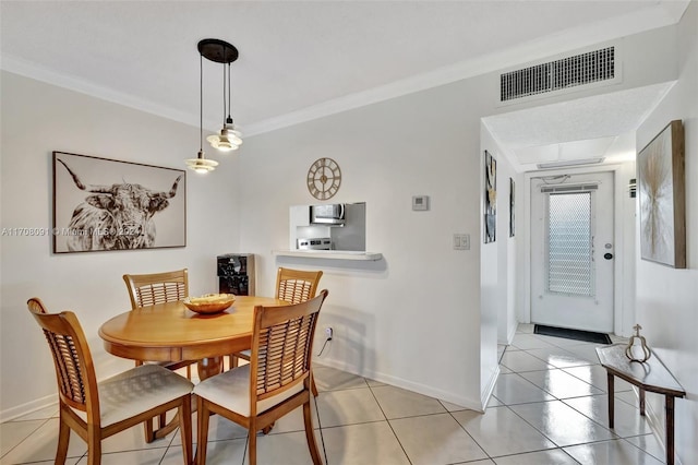 tiled dining space featuring crown molding