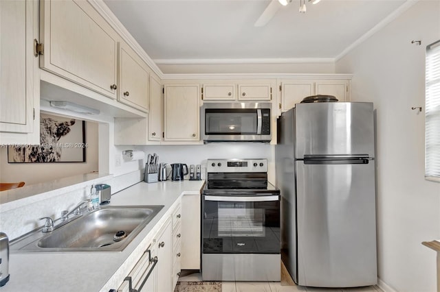 kitchen featuring appliances with stainless steel finishes, ornamental molding, ceiling fan, sink, and light tile patterned floors