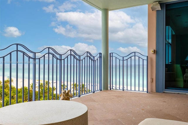 view of patio / terrace with a water view and a view of the beach