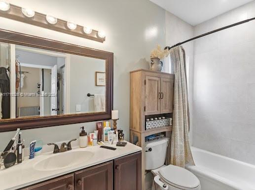 full bathroom featuring vanity, shower / tub combo, and toilet