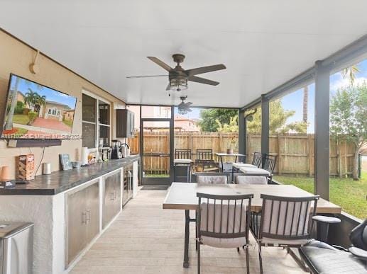 sunroom / solarium with a wealth of natural light and ceiling fan