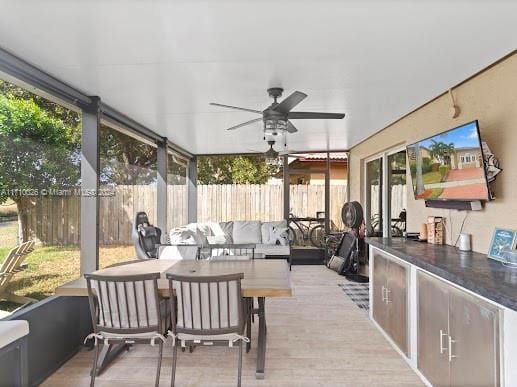 sunroom featuring ceiling fan and a healthy amount of sunlight