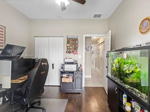 home office featuring dark hardwood / wood-style floors and ceiling fan