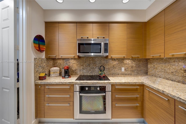 kitchen with decorative backsplash, light stone countertops, and stainless steel appliances