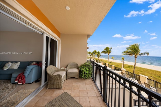 balcony featuring a water view and a beach view