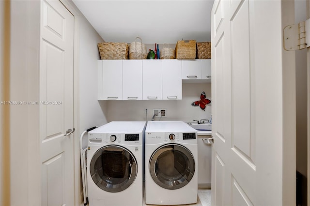 laundry area featuring cabinets, separate washer and dryer, and sink